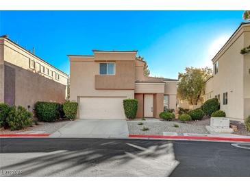 Two-story house with tan exterior, white garage door, and landscaping at 10545 Redwood Ash Ave, Las Vegas, NV 89144