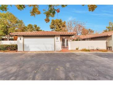 Spanish style home with a white garage door and landscaping at 3320 Plaza Del Paz, Las Vegas, NV 89102