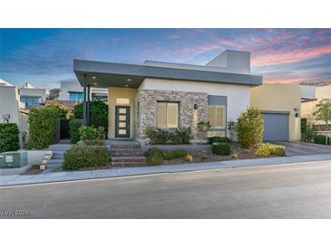 Modern home exterior with stone accents, landscaping, and a welcoming entry at 2223 Summit Mesa Ln, Henderson, NV 89052