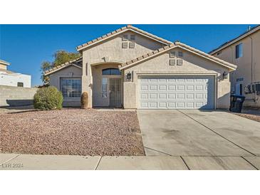 Single-story house with a two-car garage and desert landscaping at 2432 Country Valley Ct, North Las Vegas, NV 89030