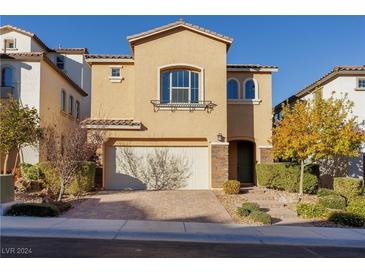 Two-story house with a neutral color scheme and a landscaped front yard at 9936 Coyote Echo Ct, Las Vegas, NV 89166