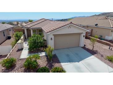 Single-story home with a two-car garage and landscaped yard at 2351 Thornwood Castle Dr, Laughlin, NV 89029