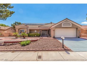 Single-story house with solar panels, landscaped yard, and double doors at 8705 Villa Ridge Dr, Las Vegas, NV 89134