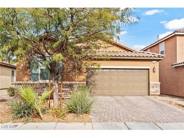 Inviting single-story home with a paved driveway, attached two-car garage, and desert landscaping at 778 Star Apple Ln, Las Vegas, NV 89178