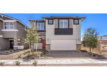 Two-story house with a red door, attached garage, and landscaping at 1053 Gentle Swan St # 676, Henderson, NV 89011