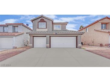 Two-story home with a two-car garage, driveway, and paver walkway at 907 Royalmile Way, North Las Vegas, NV 89032