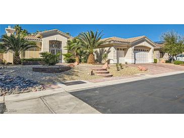 Inviting single-story home with a three-car garage, palm trees, and desert landscaping at 4729 Dream Catcher Ave, Las Vegas, NV 89129