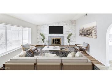 Inviting living room with a white brick fireplace, wood floors, and ample natural light at 4125 Monja Ct, Las Vegas, NV 89104