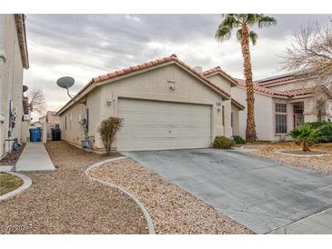 Single-story home with attached garage, driveway, and desert landscaping at 4407 Crimson Tide Ave, North Las Vegas, NV 89031