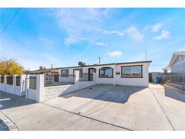 White stucco single-story home with a fenced front yard and paved driveway at 6425 Evergreen Ave, Las Vegas, NV 89107