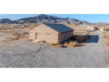 Tan house with a brown door and mountain views at 2270 Gally Rd, Pahrump, NV 89060