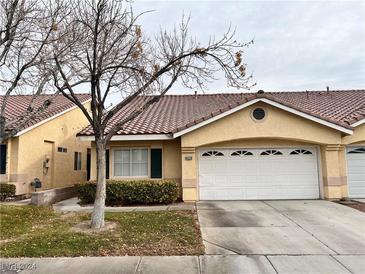 Charming two-story home with attached garage, landscaped yard, and tiled roof at 4828 Storm Mountain St, Las Vegas, NV 89130