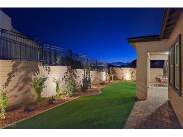 Landscaped backyard with artificial turf, sitting area, and mountain views at 144 Juliette Pointe Ln, Henderson, NV 89011