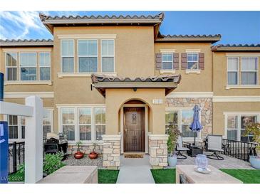 Tan two-story home with stone accents and a landscaped front yard at 3181 Mist Effect Ave, Henderson, NV 89044