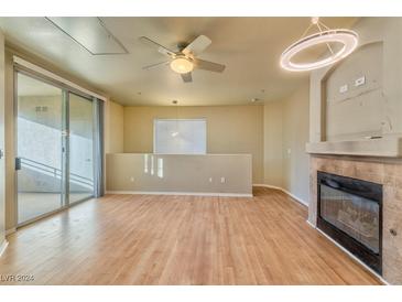 Light-filled living room features a fireplace and hardwood floors at 7151 S Durango Dr # 214, Las Vegas, NV 89113