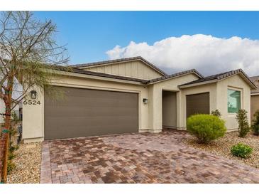 Single-story home with brown garage door and brick paver driveway at 6524 Summershade St, North Las Vegas, NV 89086