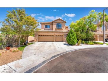 Two-story house with three-car garage and landscaped yard at 1732 Double Arch Ct, Las Vegas, NV 89128