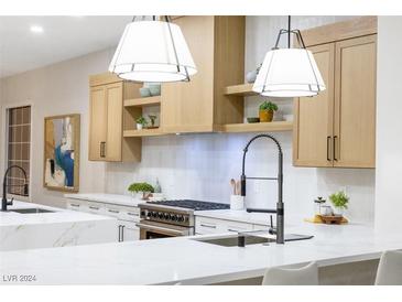 Modern kitchen featuring white quartz countertops and light wood cabinetry at 1928 Oliver Springs St, Henderson, NV 89052