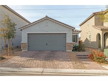 House exterior featuring a gray garage door and brick paver driveway at 4935 Enlightenment St, Las Vegas, NV 89130