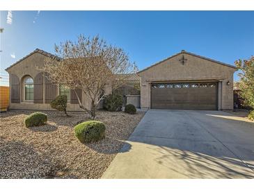 Single-story home with a two-car garage and landscaped front yard at 5704 Flying Birdie Ave, Las Vegas, NV 89122