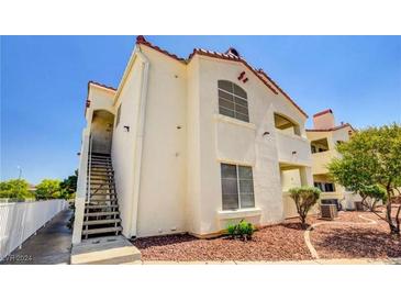 Tan two-story building with stairs and landscaping at 698 S Racetrack Rd # 214, Henderson, NV 89015