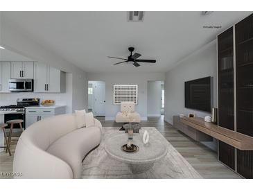 Virtually staged living room featuring a curved sofa, coffee table, and modern decor at 341 Bedford Rd, Las Vegas, NV 89107