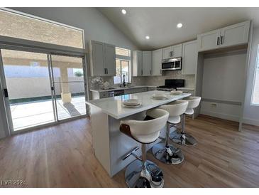 Modern kitchen with island, white cabinets, and stainless steel appliances at 9031 Aldershot Ct, Las Vegas, NV 89147