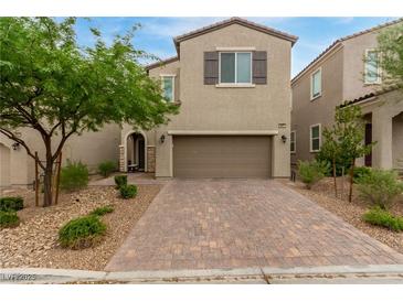 Two-story house with a brown garage door and landscaped front yard at 9851 Poplar Point Ave, Las Vegas, NV 89178