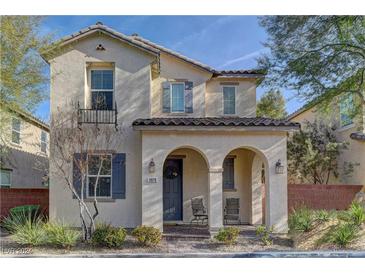 Two-story house with gray door and shutters, arched entryway, and landscaping at 11078 Neets Bay St, Las Vegas, NV 89179