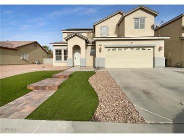 Two-story house with a landscaped front yard and attached garage at 1702 Paradise Reef Ave, North Las Vegas, NV 89031