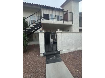 Exterior view of condo building entrance with gated access and walkway at 3923 Gogo Way # 106, Las Vegas, NV 89103