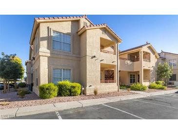 Tan two-story building with red tile roofs, landscaping, and parking at 520 Arrowhead Trl # 911, Henderson, NV 89015