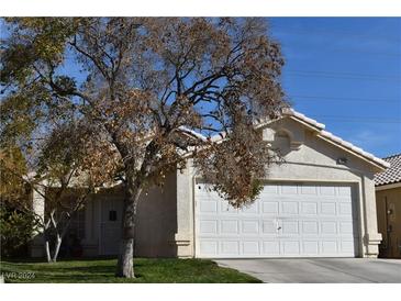 Single-story house with a white garage door and mature tree in the front yard at 3652 Copper Cactus Dr, Las Vegas, NV 89129