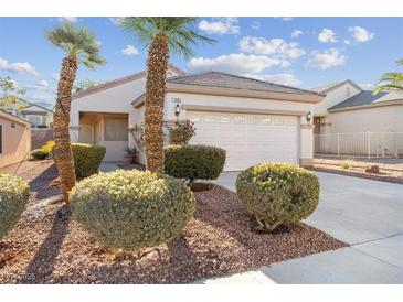 Single-story house with a two-car garage and desert landscaping at 1805 Walking Path Ave, Henderson, NV 89012