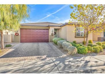 Single-story home with landscaped front yard, red door, and two-car garage at 5732 Swan Bridge St, North Las Vegas, NV 89081