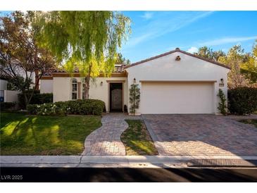 Single-story home with a white exterior, landscaped yard, and two-car garage at 11775 Woodbrook Ct, Las Vegas, NV 89141