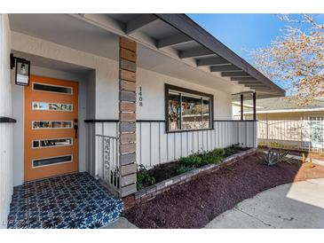 Mid-century modern home exterior with orange door and landscaped entryway at 1408 S 16Th St, Las Vegas, NV 89104