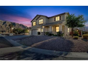 Two-story house with a three-car garage and landscaped yard at dusk at 6491 Bristle Canyon Ave, Las Vegas, NV 89110