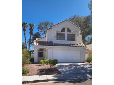 Two-story house with a white exterior, two-car garage, and landscaping at 92 Sea Holly Way, Henderson, NV 89074