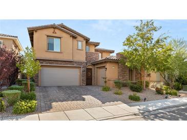 Two-story house with tan exterior, stone accents, and a three-car garage at 288 Molinetto St, Las Vegas, NV 89138