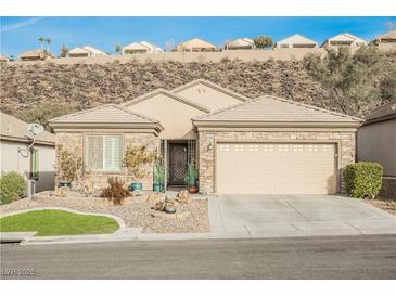 Single-story home with stone accents, landscaped yard, and two-car garage at 2406 Jada Dr, Henderson, NV 89044