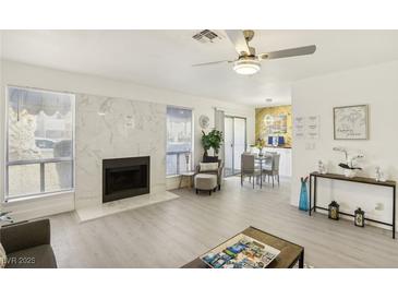 Bright living room with fireplace, dining area, and access to patio at 4975 Newport Cove Dr # B, Las Vegas, NV 89119