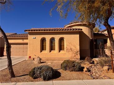 Single-story home with stucco exterior, three arched windows, and a landscaped front yard at 7017 Arcadia Creek St, North Las Vegas, NV 89084