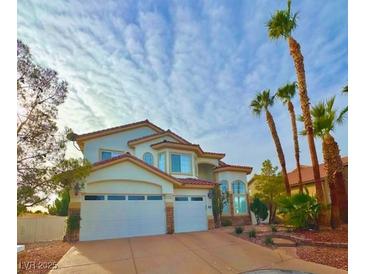 Two-story house with three-car garage and desert landscaping at 9703 Newport Coast Cir, Las Vegas, NV 89147