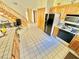 Kitchen features wood cabinets, black appliances, and tile floor at 2089 Avalon Dr, Laughlin, NV 89029