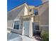 Two story beige townhouse with white door and landscaping at 5855 Valley Dr # 2096, North Las Vegas, NV 89031