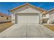 Front view of a house with a white garage door and a concrete driveway at 5717 Wizard Wand St, North Las Vegas, NV 89031