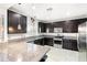 Modern kitchen with dark cabinetry, granite counters, and stainless steel appliances at 10622 Cliff Lake St, Las Vegas, NV 89179