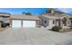 Front exterior view of the house with double garage, stone accents, and landscaping at 909 Rhyolite Ter, Henderson, NV 89011