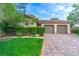 Single story home with two car garage and manicured lawn at 79 Emerald Dunes Cir, Henderson, NV 89052